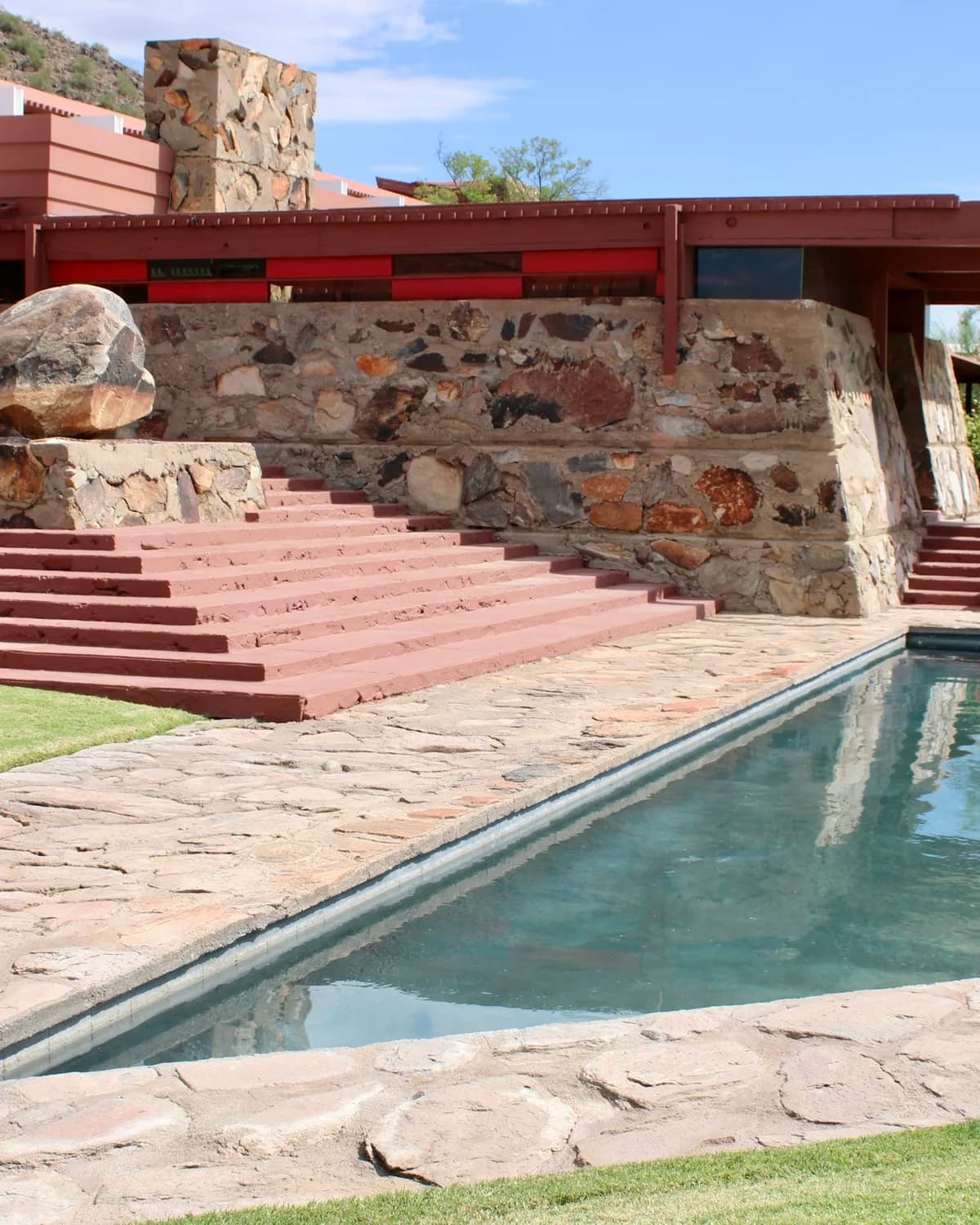 Desert architecture pool with geometric edge, flagstone deck, and mountain backdrop at Taliesin West, Scottsdale, Arizona