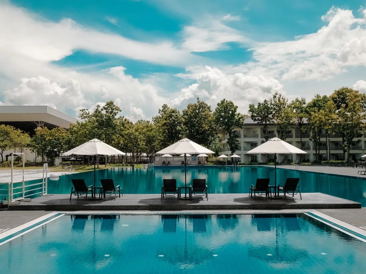 Crystal-clear geometric pool water under white umbrellas, balanced and bright